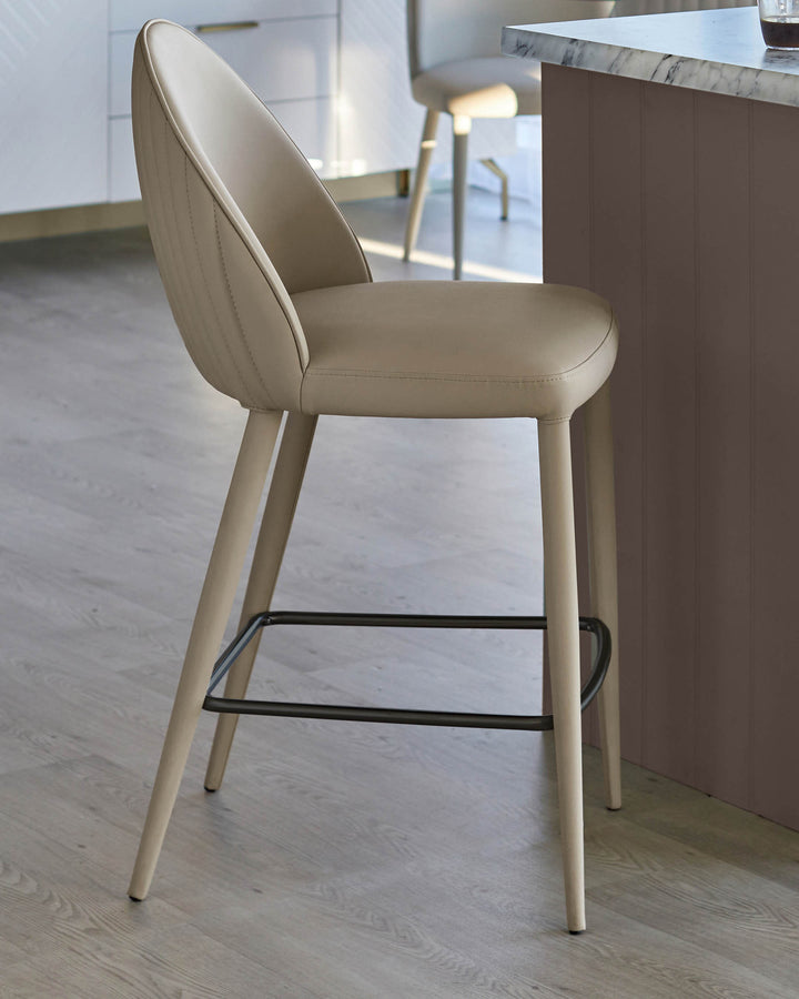 Upholstered bar stool in neutral tones with black metal footrest. Kitchen furniture.