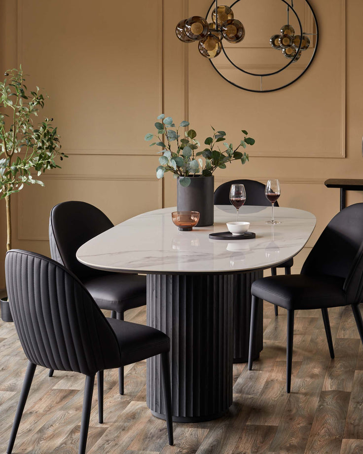 A modern dining set with black chairs and a marble-look table, perfect for stylish homes.