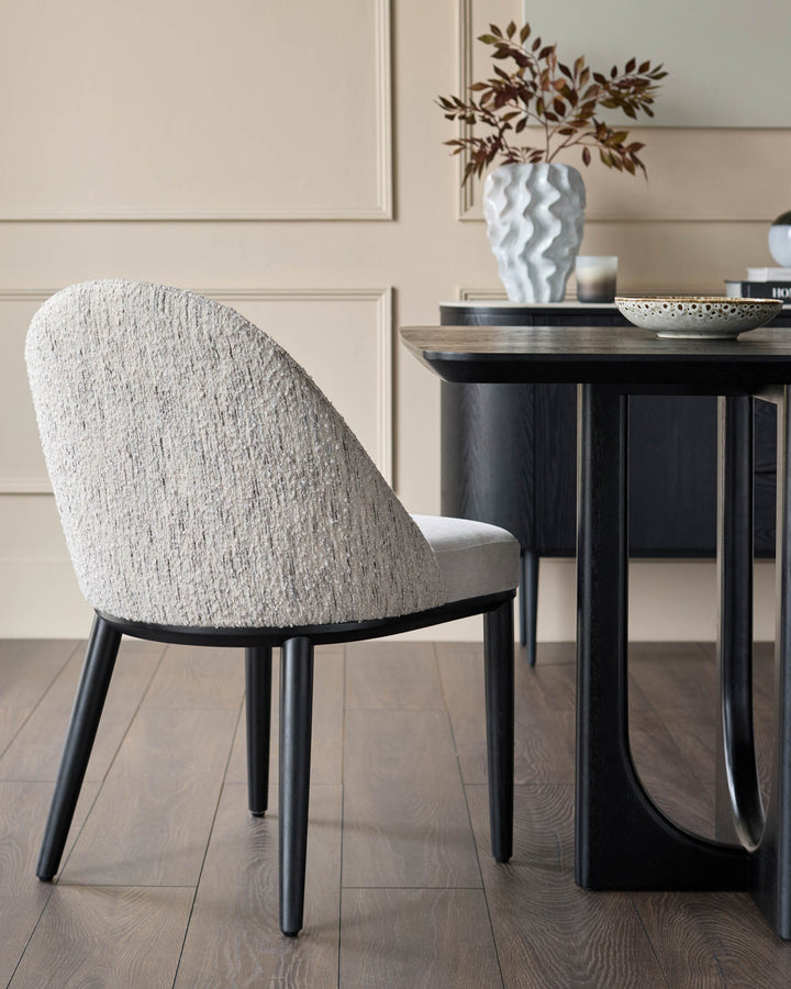 A contemporary dining set, featuring a textured chair and dark wood table, exudes modern elegance.