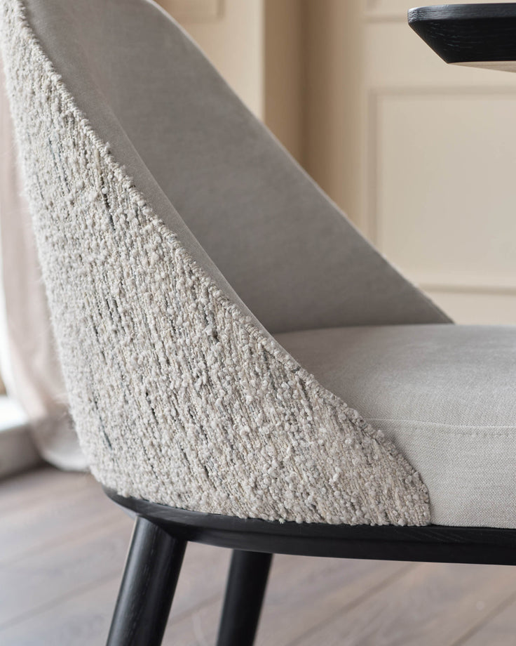 Close-up of a stylish chair with textured backrest and sleek black legs, offering comfort and modern design.