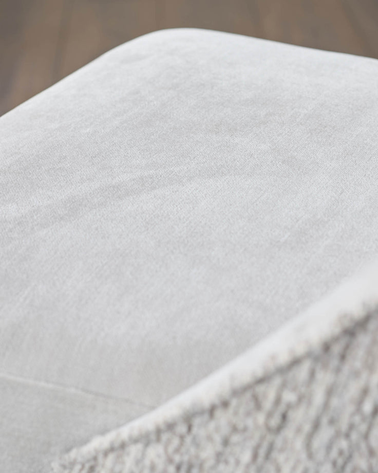 Close-up of a cream textured fabric chair, part of a stylish and comfortable furniture set.