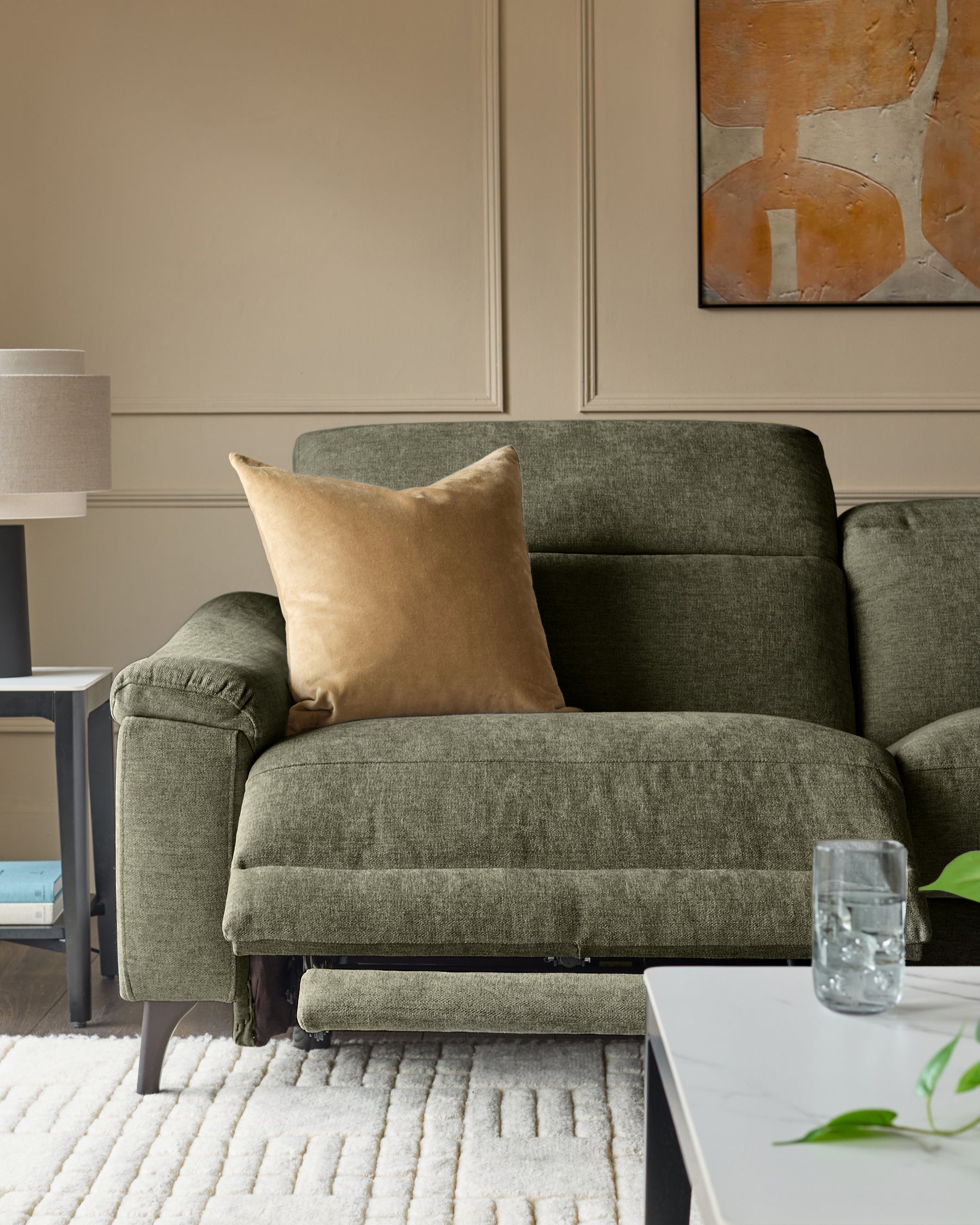 Dark green fabric 3-seater recliner sofa with extended footrest, gold cushion, and wooden legs in modern living room setting.