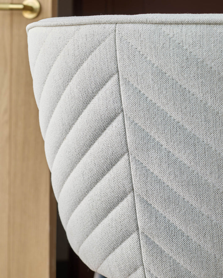 Close-up of a stylish grey chair with a geometric pattern, providing a comfortable and modern seating option.