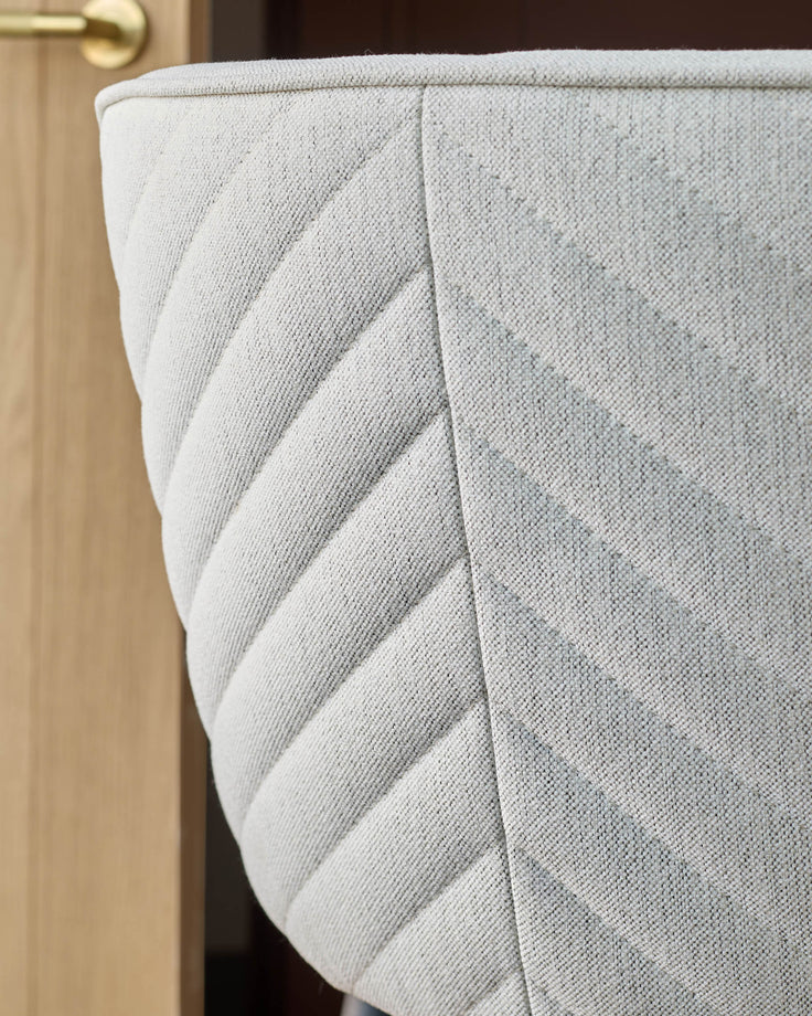 Close-up of a stylish grey chair with a geometric pattern, providing a comfortable and modern seating option.
