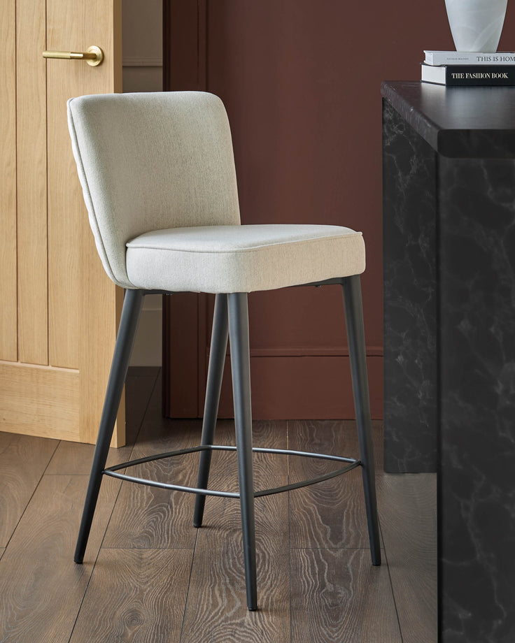 Upholstered bar stool with grey metal legs, set in a modern kitchen environment.