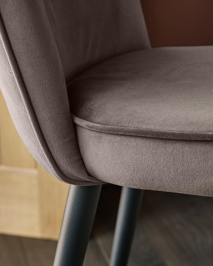 Serena mocha velvet bar stool with curved backrest and black metal legs, shown in close-up detail.