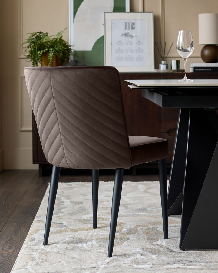 Mocha velvet dining chair with quilted backrest and black metal legs, shown in a styled dining room setting.