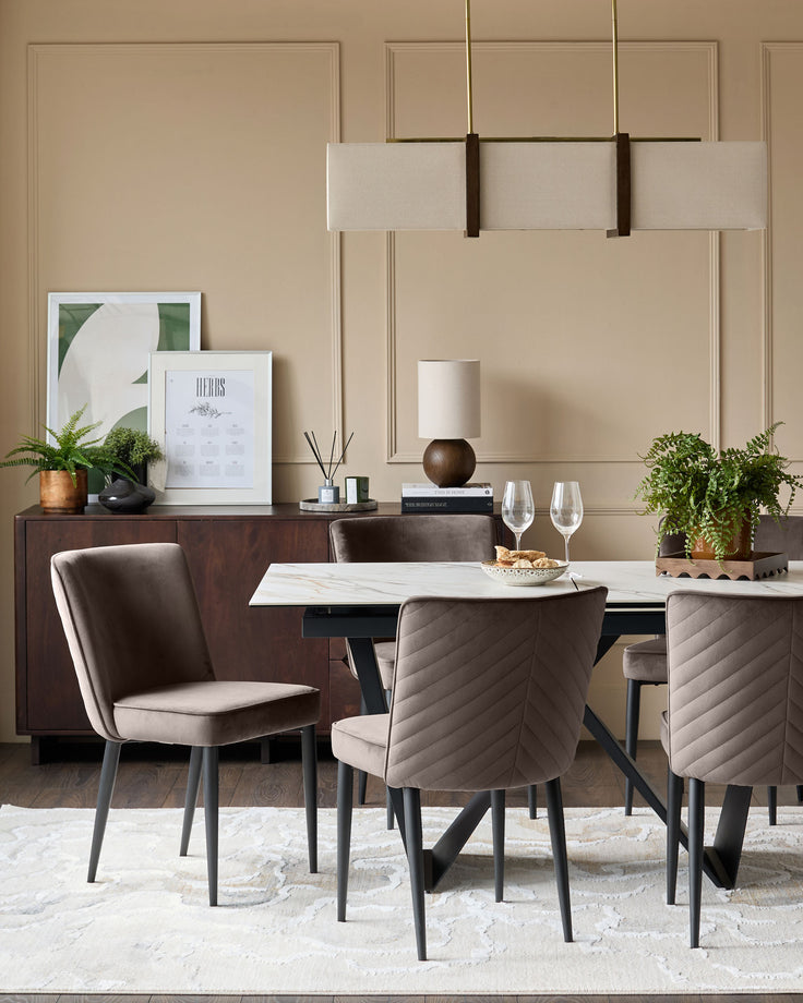 Mocha velvet dining chair with quilted backrest and black legs, shown in a styled dining room setting.