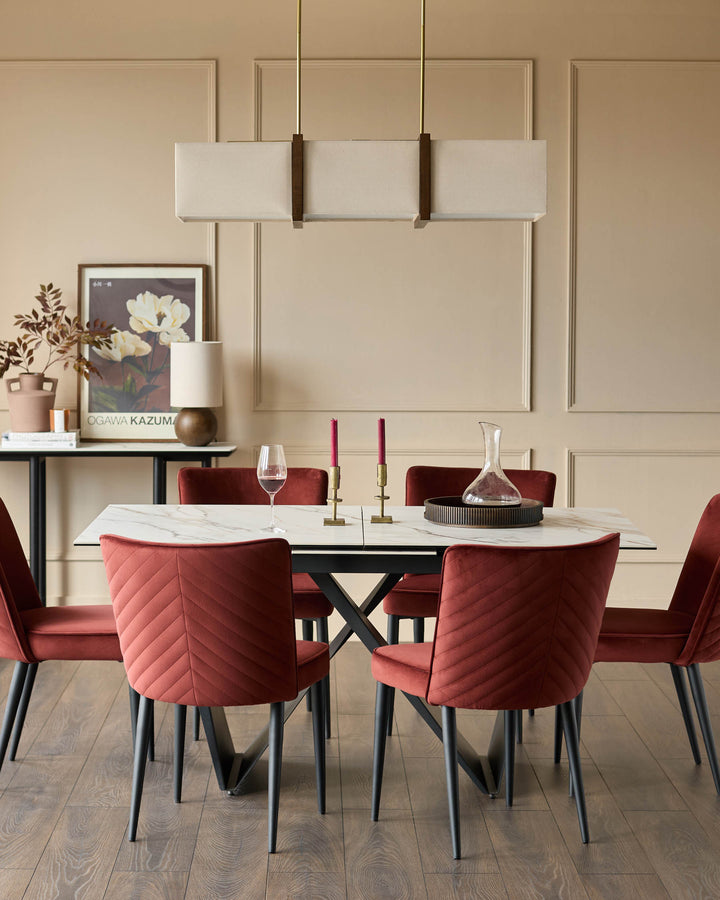 A modern dining set with a marble-effect table, 6 red velvet chairs, and an overhead light fixture.