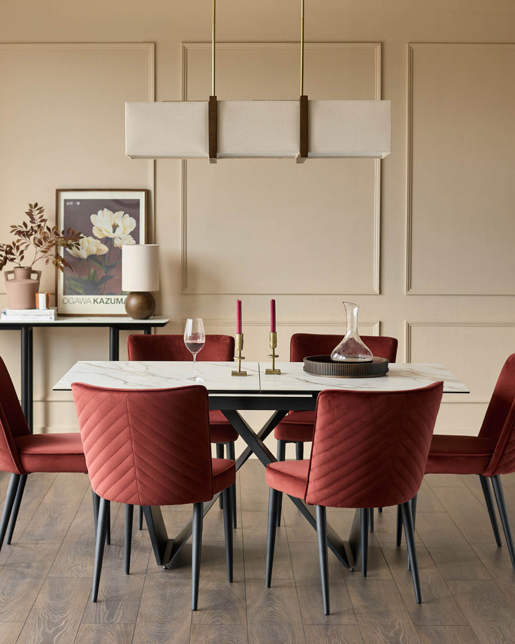 A modern dining set with a marble-effect table, 6 red velvet chairs, and an overhead light fixture.
