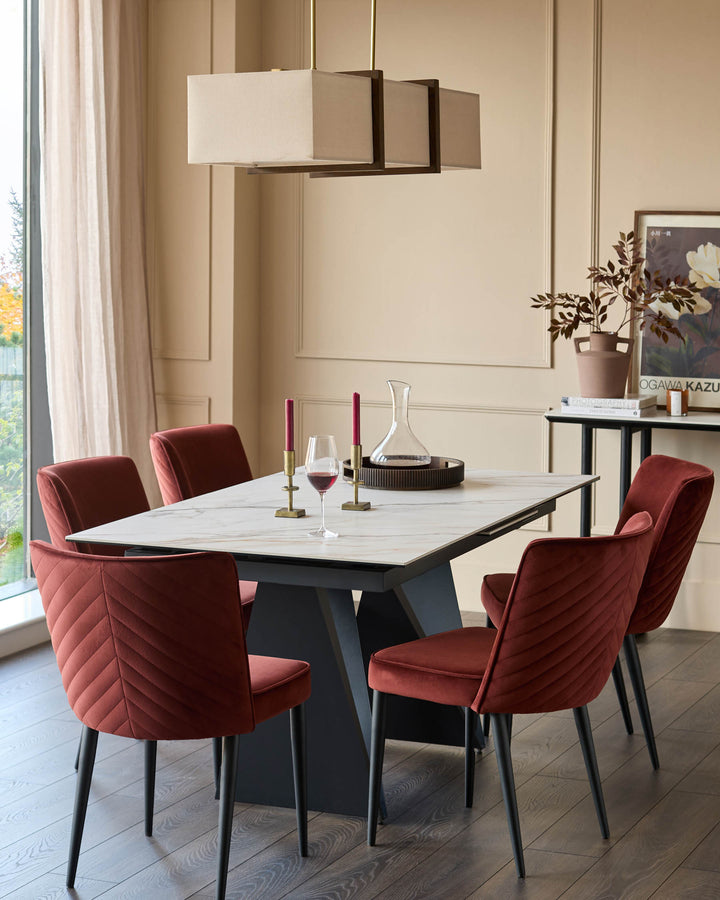 Dining set featuring a modern table with marble effect top and stylish, deep red velvet chairs.