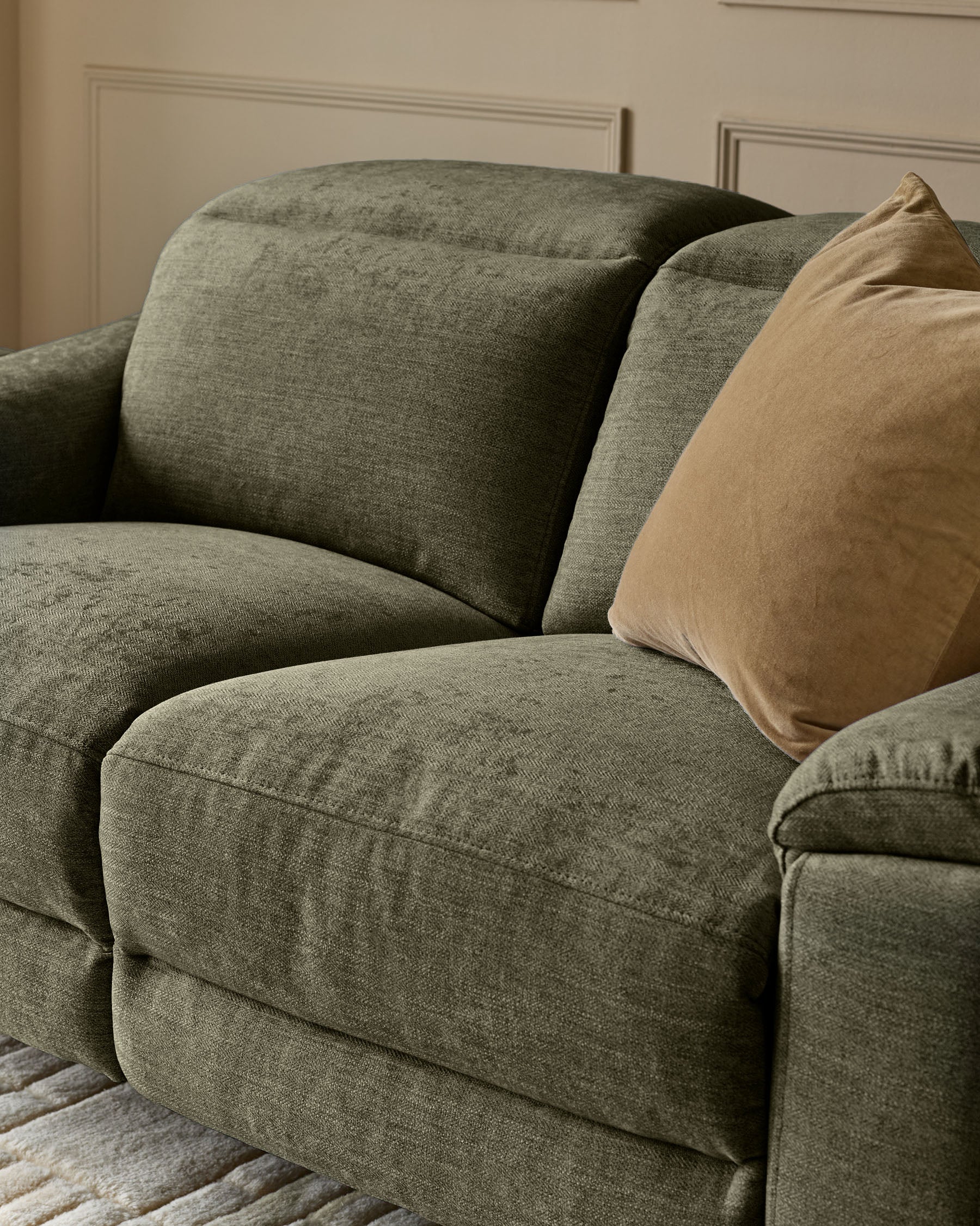 Serene 3-seater fabric recliner sofa in dark green with rounded armrests and a tan cushion, angled side view.