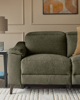 Serene 3-seater fabric recliner sofa in dark green with curved arms and wooden legs, positioned in a modern living room setting.