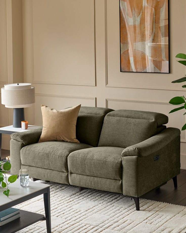 Dark green 2-seater recliner sofa with padded arms and headrests, featuring black tapered legs in a contemporary living room setting.