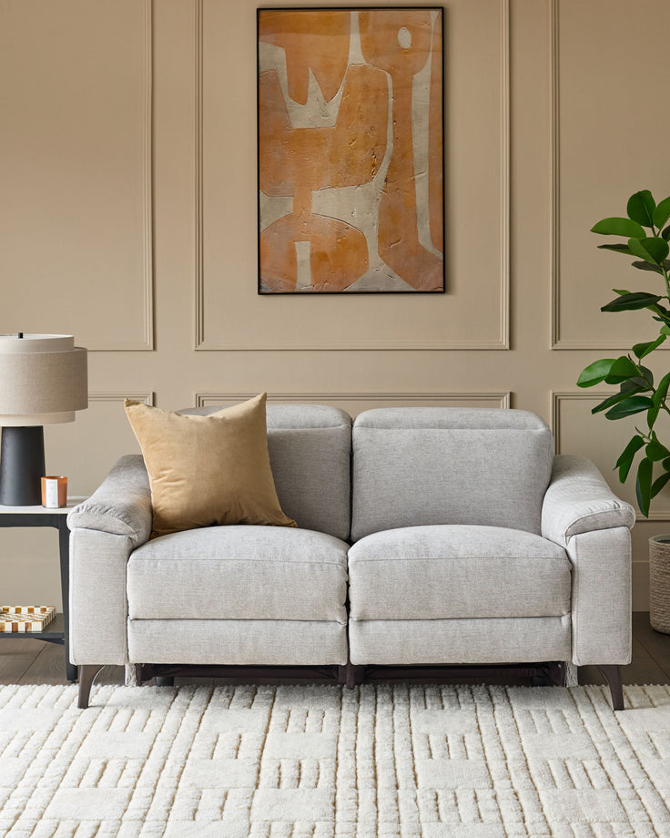 Serene light grey 2-seater fabric recliner sofa with rolled arms and dark wooden legs, styled in a neutral living room.