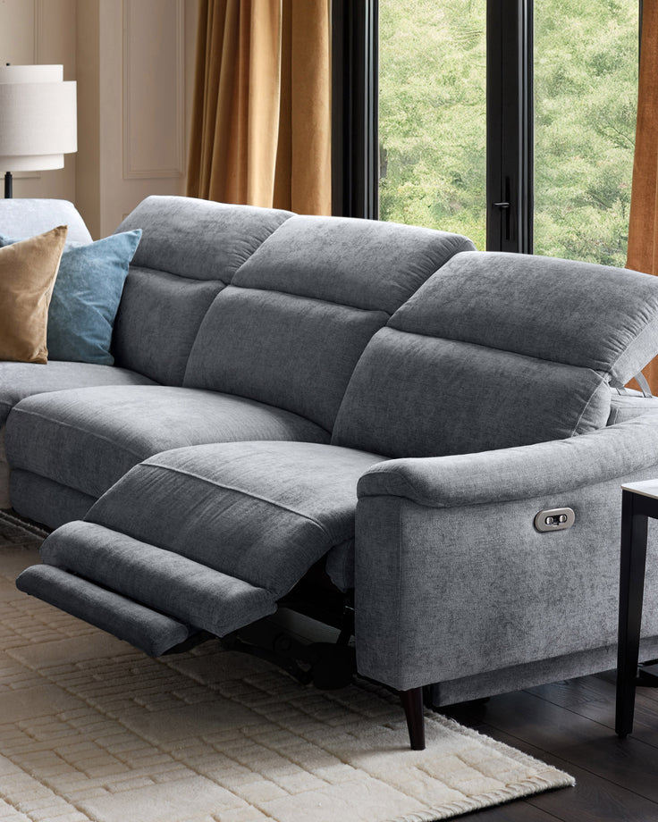 Serene left chaise recliner sofa in blue-grey chenille with footrest extended, shown in modern living room setting.