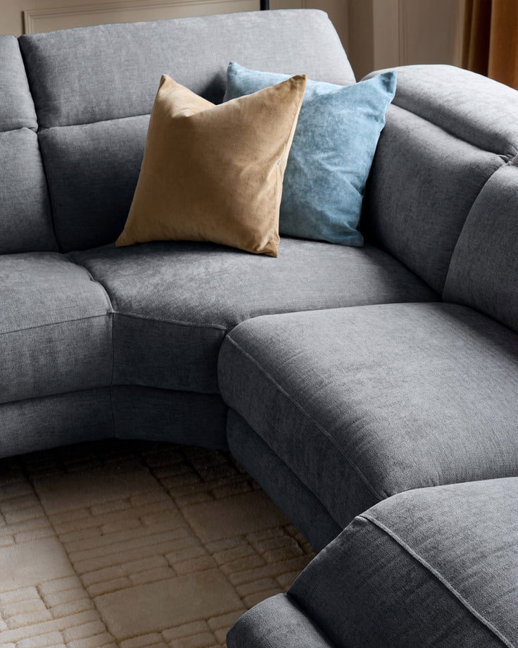 Serene left chaise recliner sofa in blue-grey chenille with decorative gold and blue throw pillows.