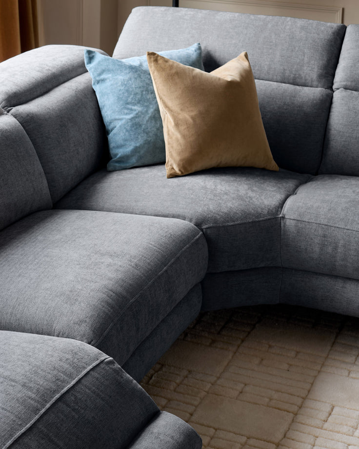 Serene right chaise recliner sofa in blue-grey chenille with decorative pillows in blue and tan.