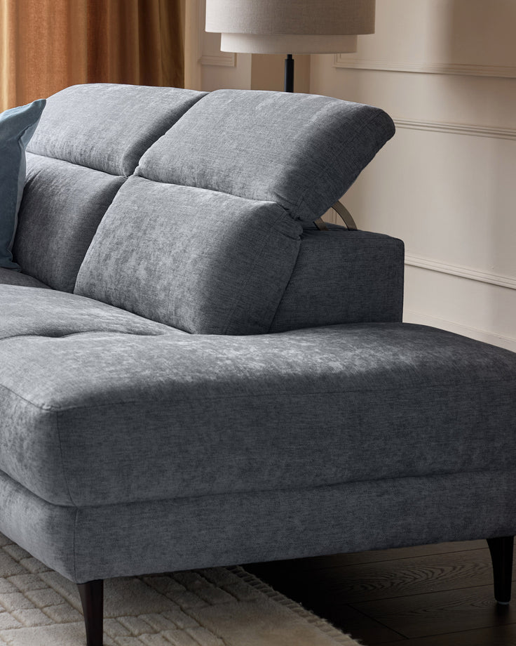 Serene right chaise recliner sofa in blue-grey chenille with adjustable backrest pillows and tapered dark legs, angle view.
