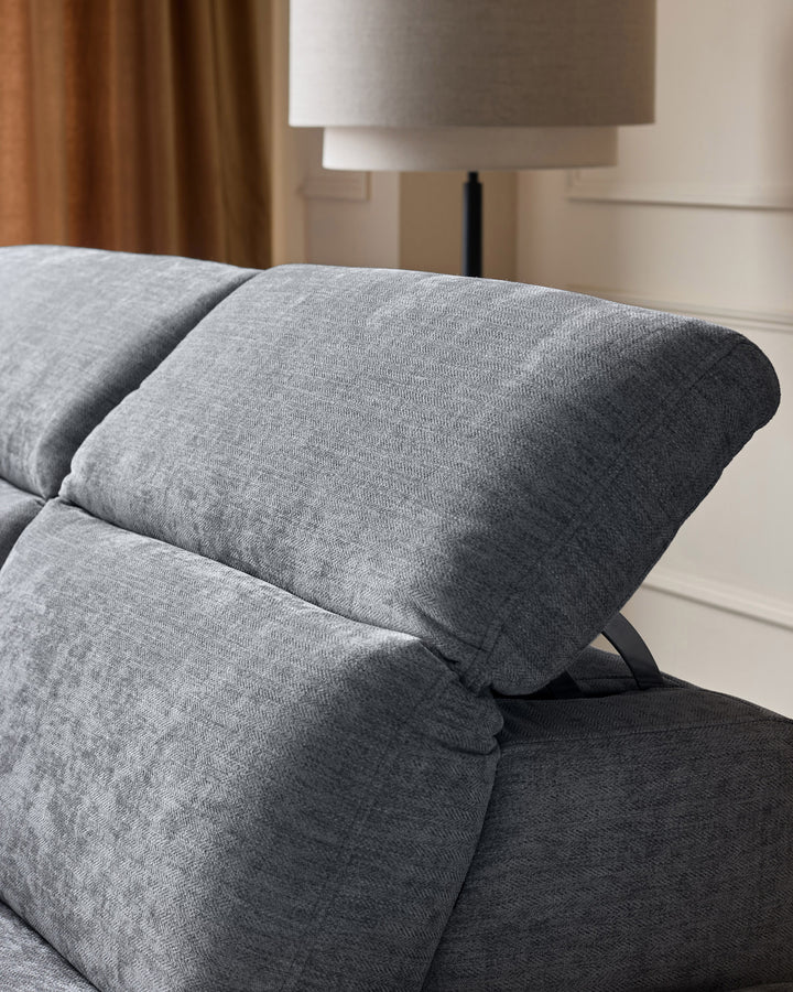 Grey chenille right chaise recliner sofa with rolled armrest and angled leg detail, shown in bedroom setting.