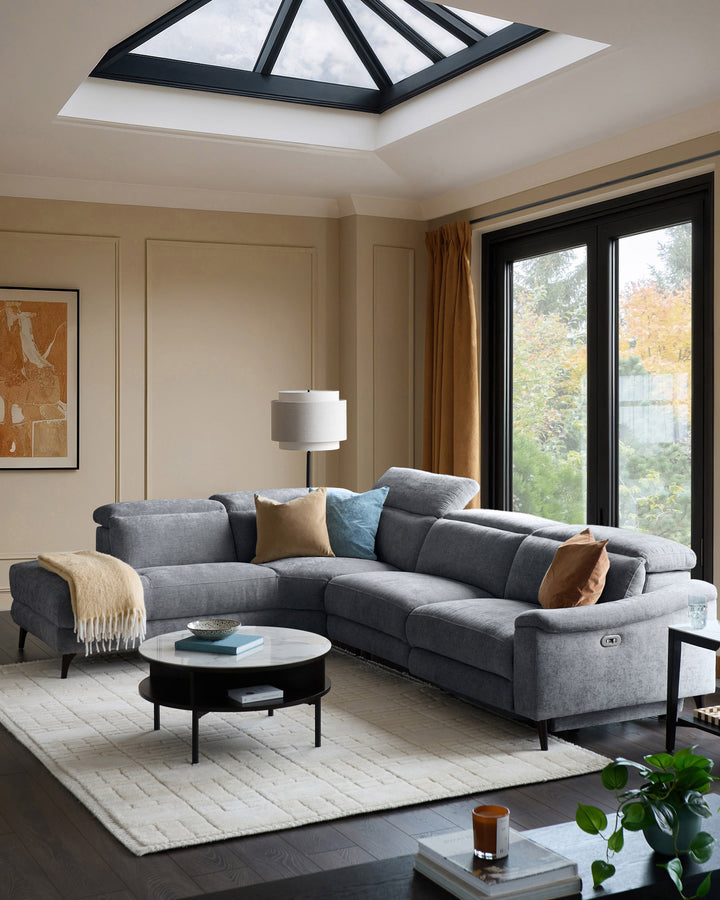 Serene left chaise recliner sofa in blue-grey chenille, displayed in a modern living room with skylight and black-framed doors.