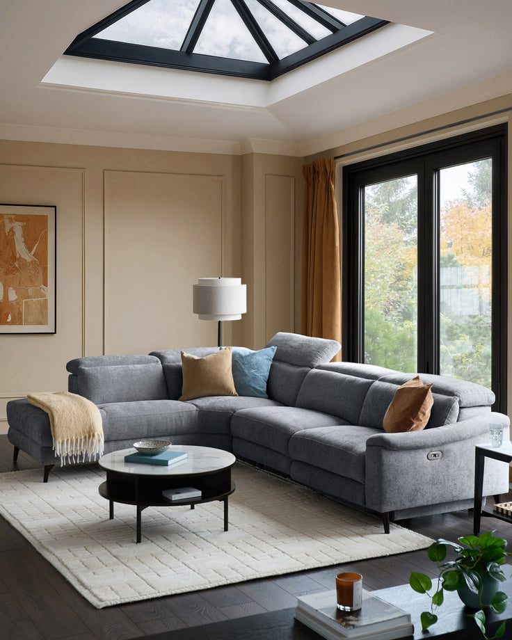 Serene left chaise recliner sofa in blue-grey chenille, displayed in a modern living room with skylight and black-framed doors.