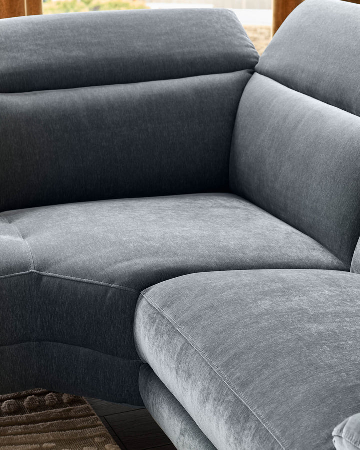 Serene right small corner recliner sofa in blue-grey fabric, showing cushioned seat and backrest detail with stitched seams.