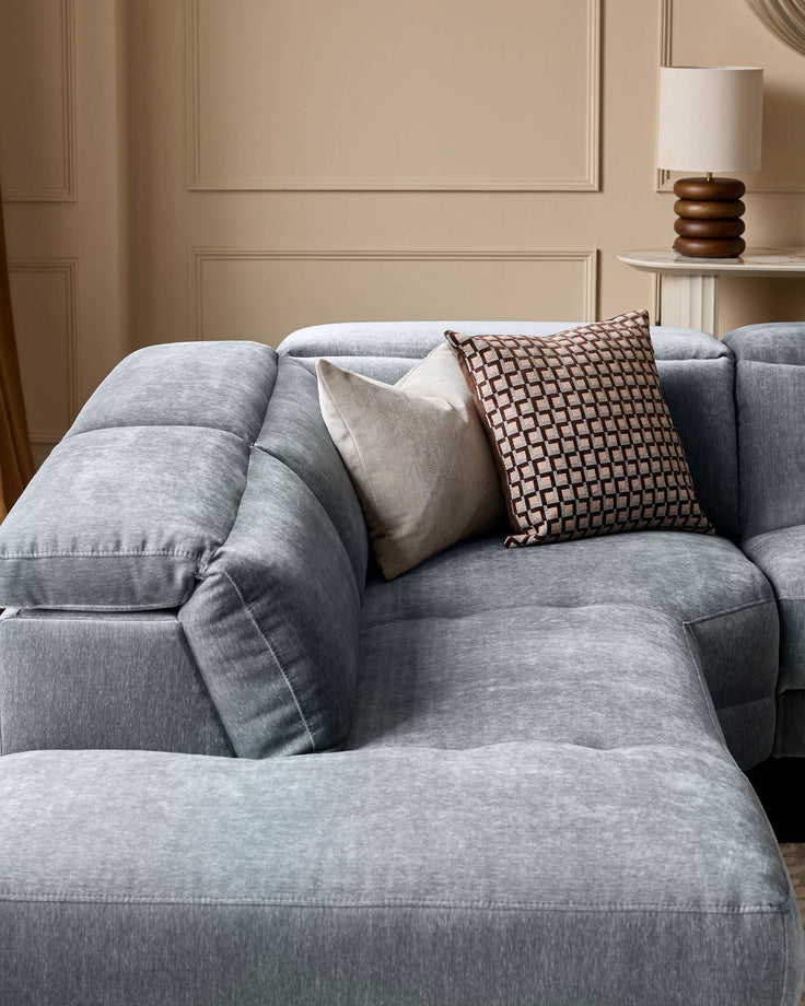 Serene left small corner recliner sofa in blue-grey fabric with decorative pillows in a neutral interior setting.