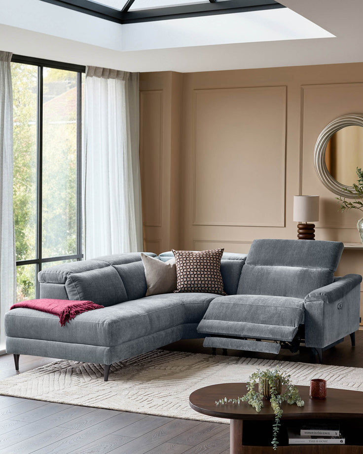 Serene left small corner recliner sofa in blue-grey fabric, displayed in a modern living room with one recliner extended.