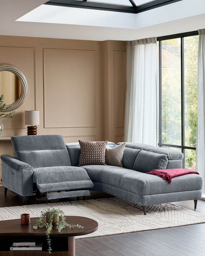 Serene right small corner recliner sofa in blue-grey fabric, displayed in bright living room with skylights and large windows.