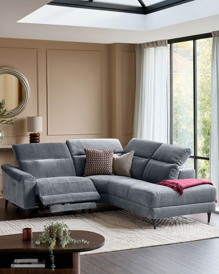 Serene right small corner recliner sofa in blue-grey fabric with extended footrest, positioned in modern living room with skylight.