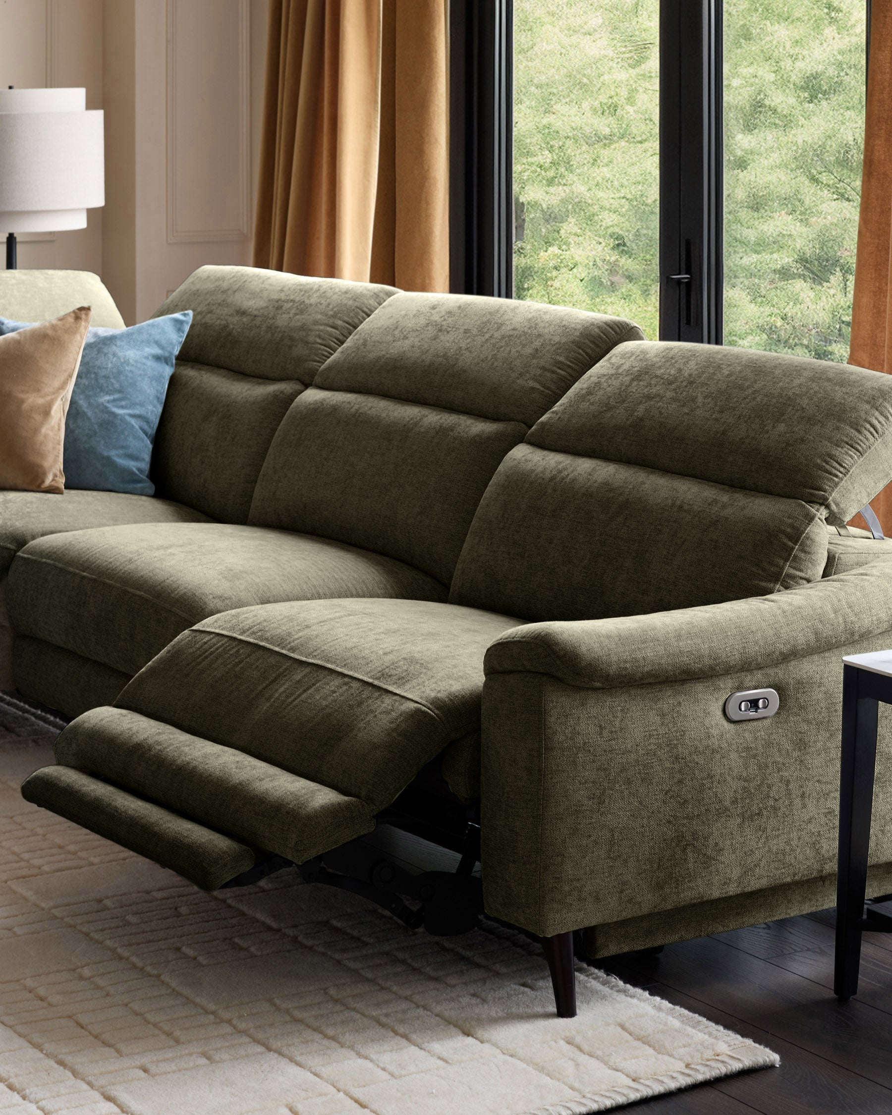 Serene left chaise recliner sofa in dark green chenille with footrest extended, shown in modern living room setting.
