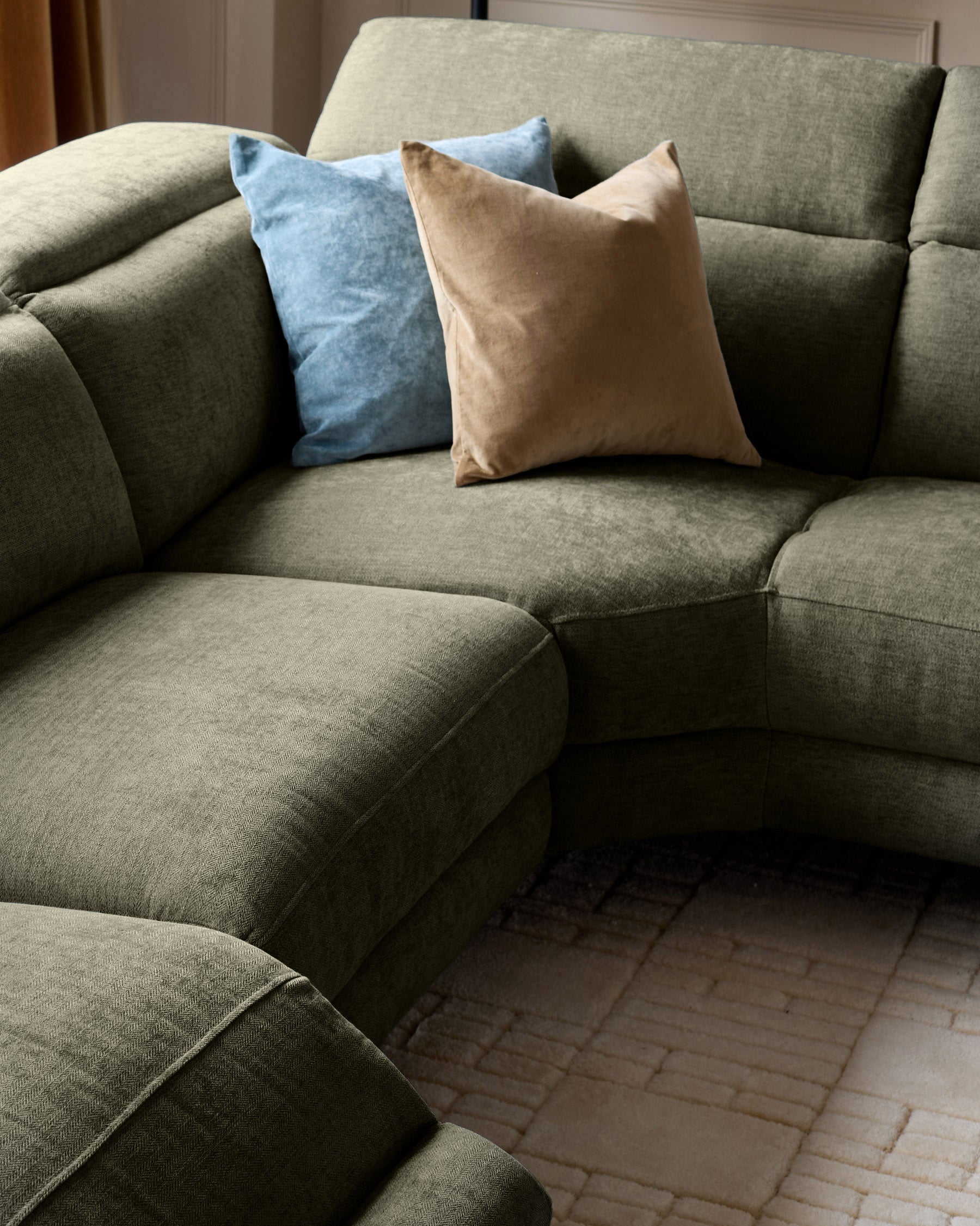 Serene right chaise recliner sofa in dark green chenille with decorative blue and tan pillows, angled view.