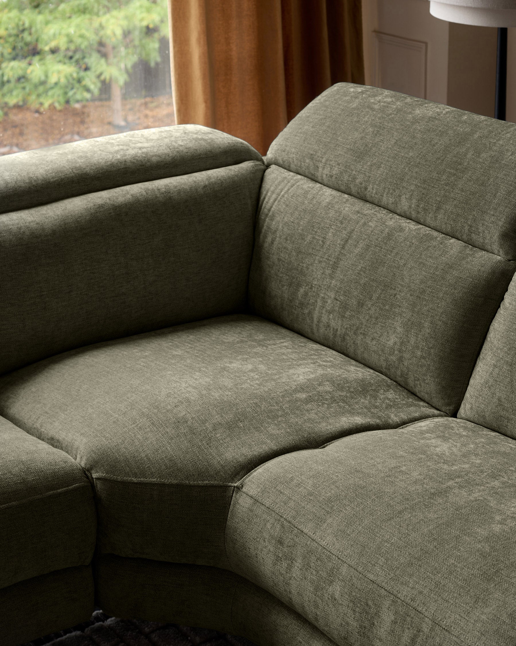 Serene left chaise recliner sofa in dark green chenille, close-up detail view showing cushioned seat and back.