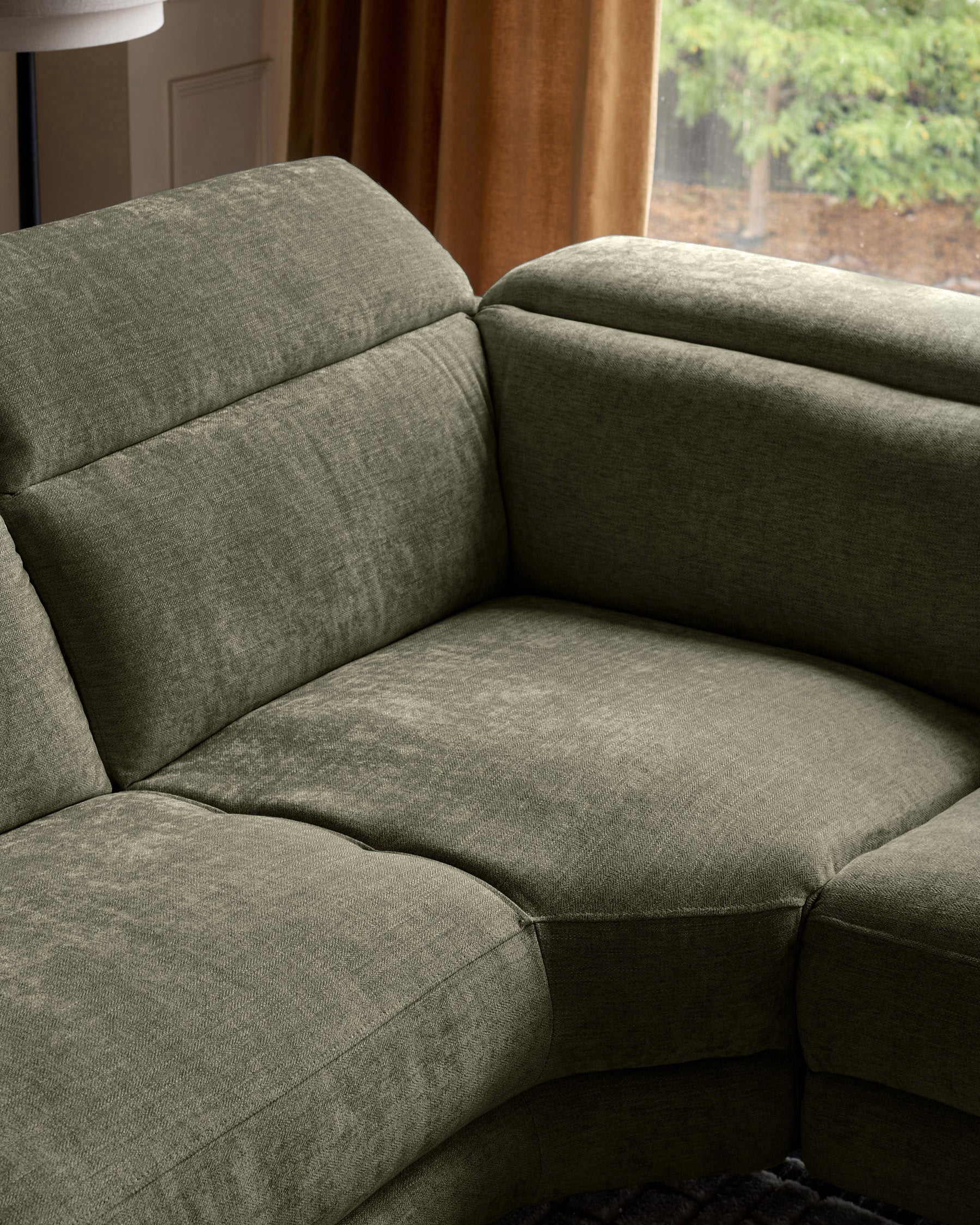Serene right chaise recliner sofa in dark green chenille, shown at an angle highlighting the plush cushioning and armrest design.