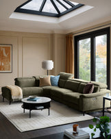 Serene left chaise recliner sofa in dark green chenille, displayed in a modern living room with skylight and garden views.