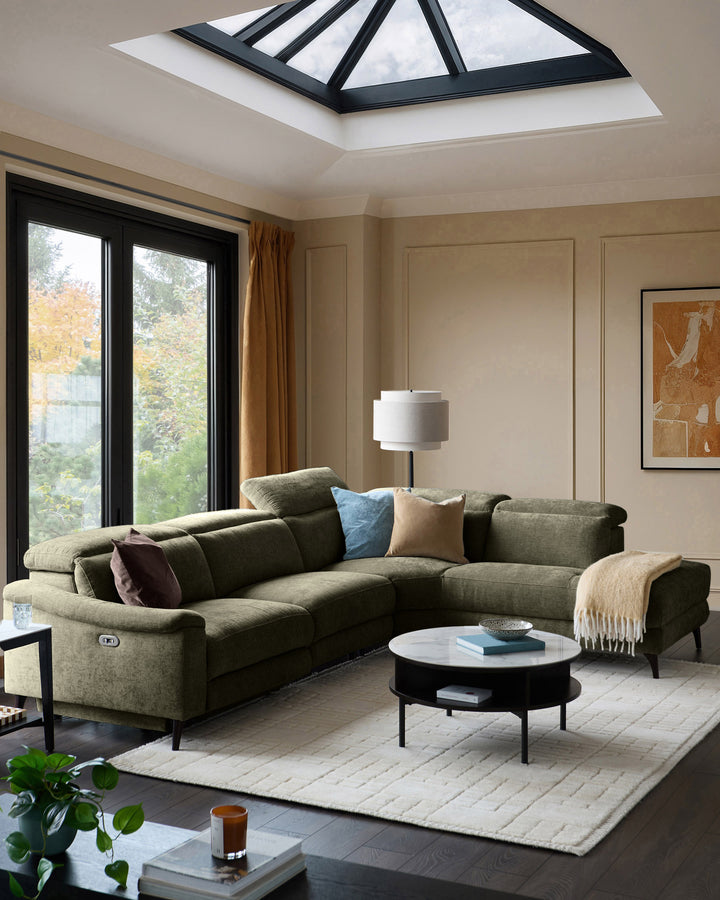 Serene right chaise recliner sofa in dark green chenille, displayed in a modern living room with reclined position visible.