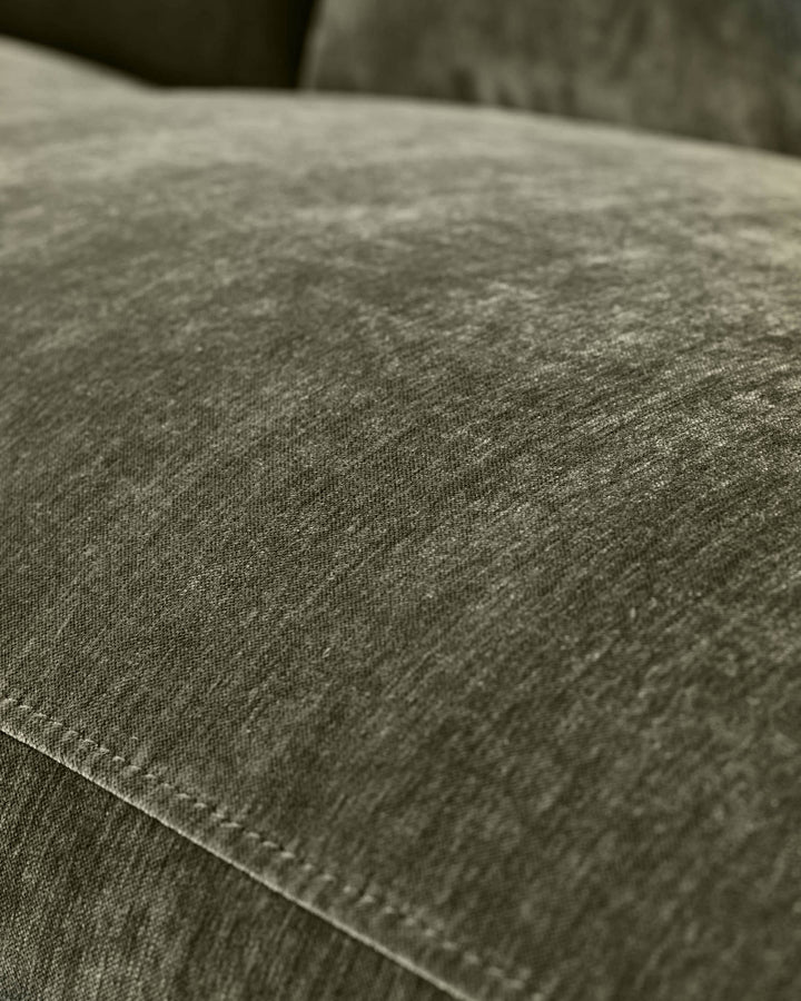 Close-up of dark green fabric texture on Serene 2-seater recliner sofa, showing weave detail and stitching.