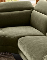 Serene Left Small Corner Recliner Sofa in dark green fabric, showing curved seating with rolled armrests and stitched details.