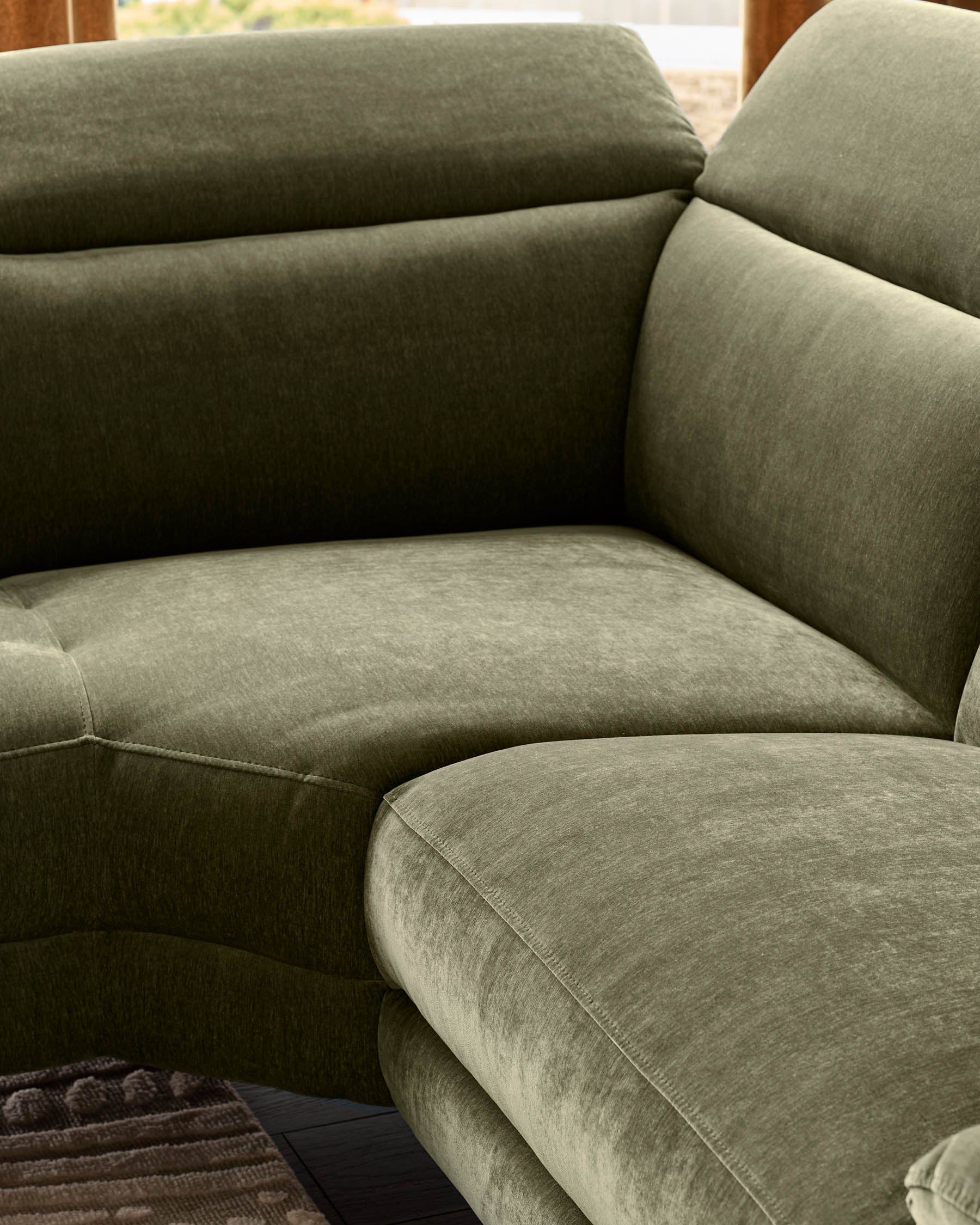 Serene Left Small Corner Recliner Sofa in dark green fabric, showing curved seating with rolled armrests and stitched details.