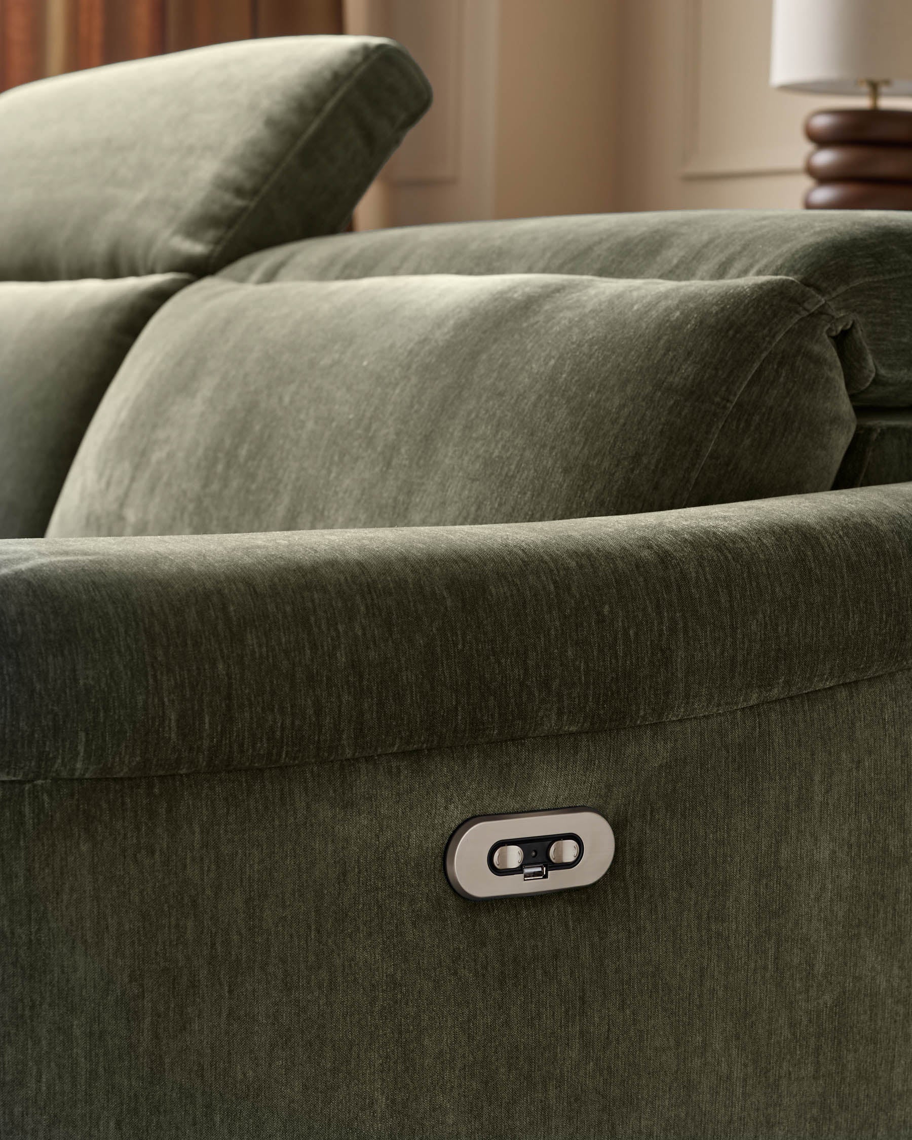 Dark green fabric left corner recliner sofa with control button visible on armrest, styled with cushions in neutral room setting.