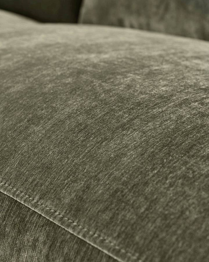 Close-up of dark green fabric texture on Serene left small corner recliner sofa, showing weave detail and stitching.