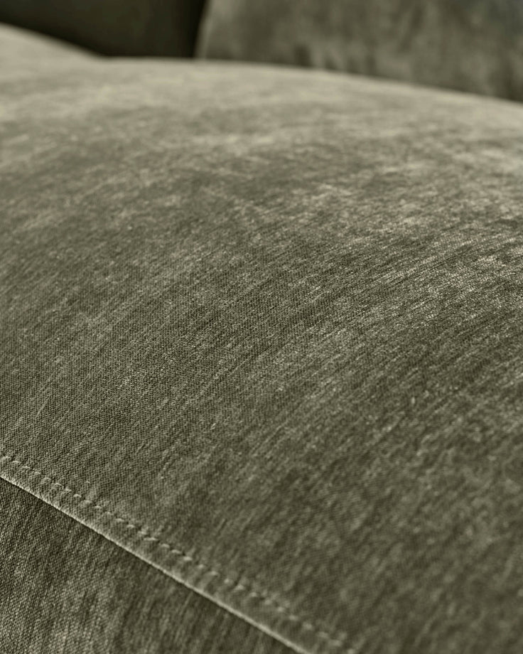 Close-up of dark green fabric on Serene right small corner recliner sofa, showing texture and stitching detail.