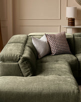 Dark green fabric left-corner recliner sofa with decorative pillows in a neutral, paneled room setting.