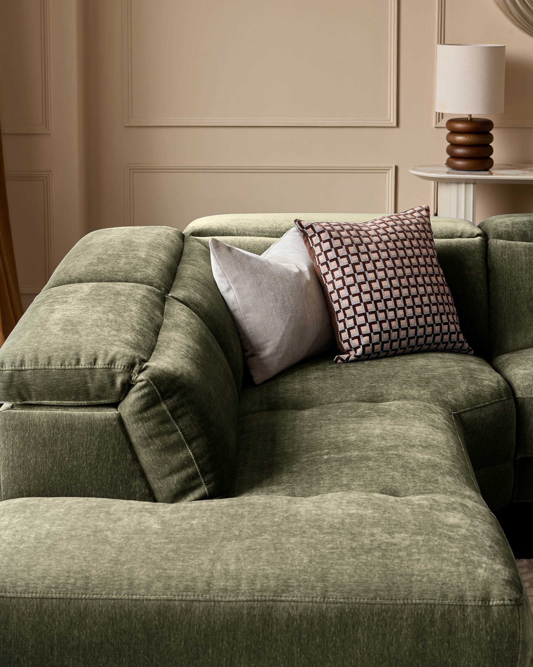 Dark green fabric left-corner recliner sofa with decorative pillows in a neutral, paneled room setting.