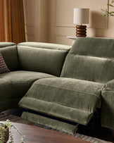 Serene left small corner recliner sofa in dark green fabric with extended footrest, shown in modern living room setting.