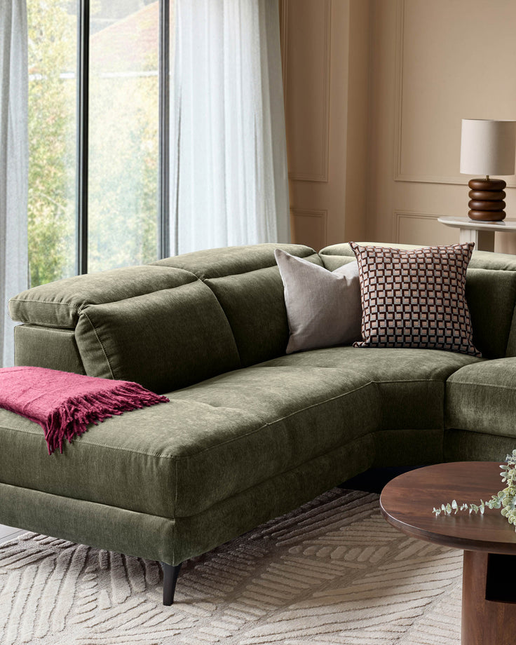 Serene left small corner recliner sofa in dark green fabric, styled with decorative pillows and throw blanket in a bright living room.