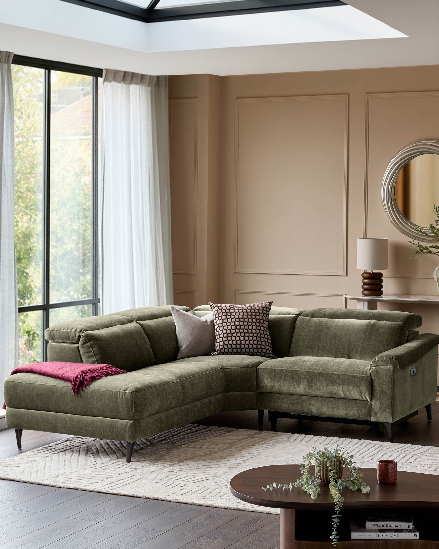 Serene left small corner recliner sofa in dark green fabric, displayed in a modern living room setting with neutral walls and natural lighting.
