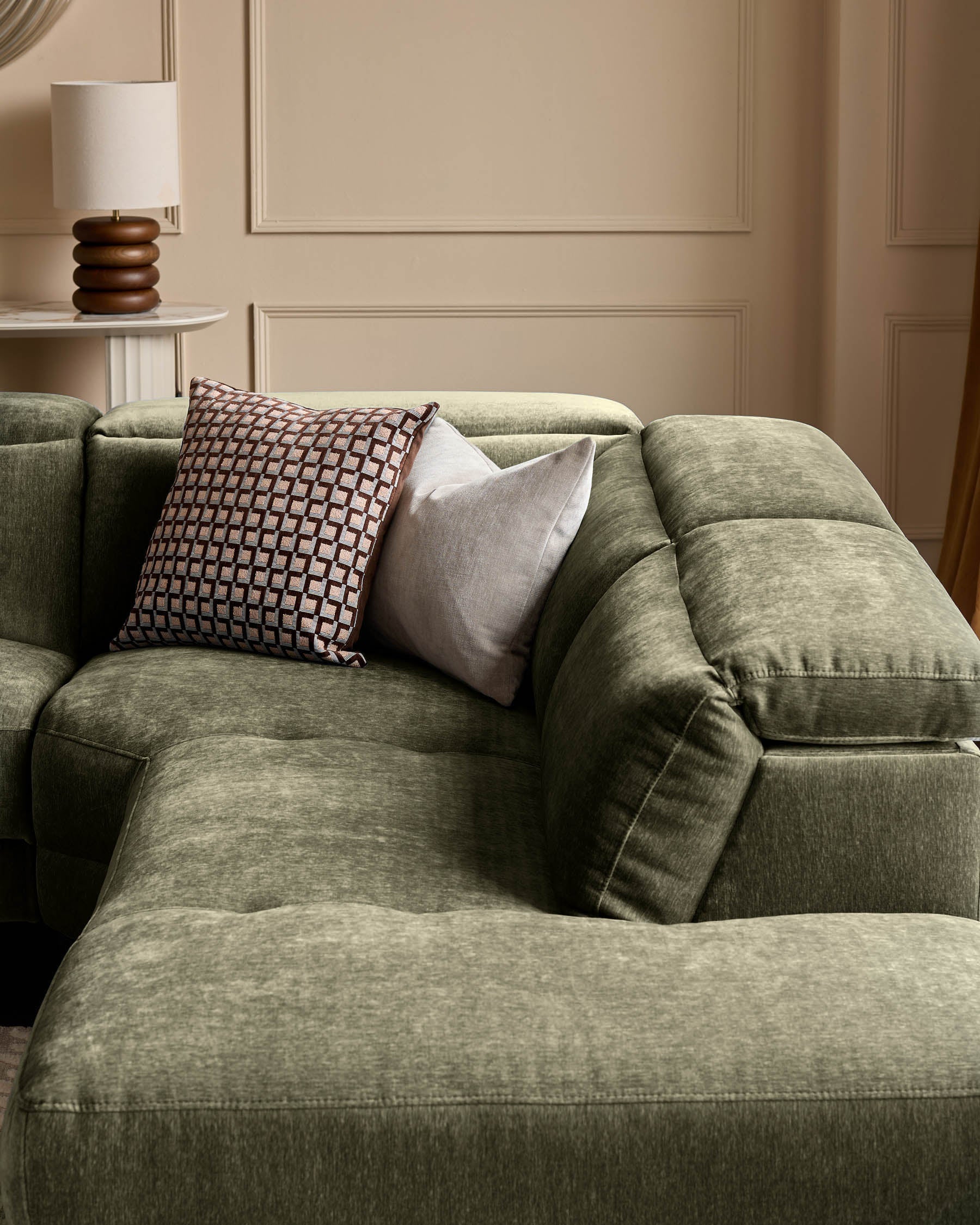 Serene right small corner recliner sofa in dark green fabric with decorative pillows in a neutral beige interior setting.