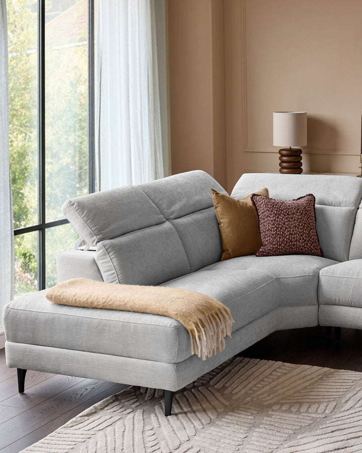Light grey fabric left-corner recliner sofa with padded backrest, tapered legs, styled with gold throw and patterned pillows.